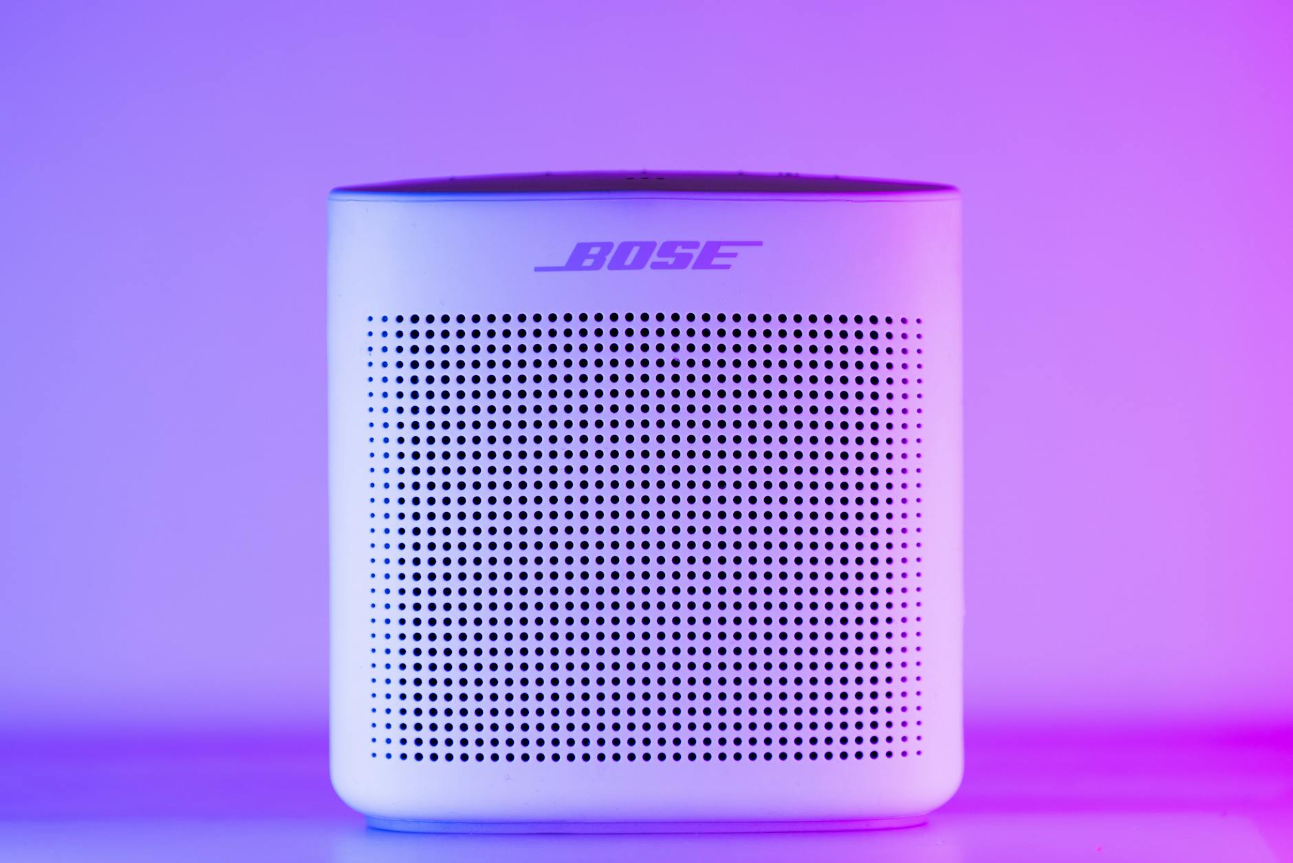 modern bluetooth speaker highlighted in purple light